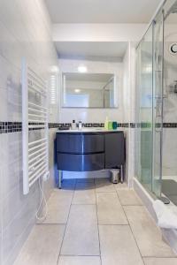a bathroom with a sink and a glass shower at Le cocon Champenois-Parking, centre & Tram in Reims +20 photos