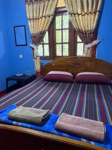a bedroom with a large bed with two towels on it at Pink House Ella in Ella +3 photos
