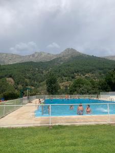 Una piscina con gente y montañas al fondo. en Casa Real, en El Arenal