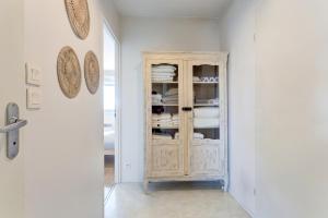 a room with a cabinet with dishes in it at Le cocon Champenois-Parking, centre & Tram in Reims +22 photos