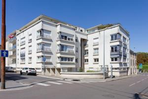 a white apartment building on the corner of a street at Le cocon Champenois-Parking, centre & Tram in Reims
