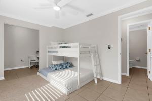 a white bunk bed in a white room with a desk at Helene's Coastal Escape in Sarasota +11 photos