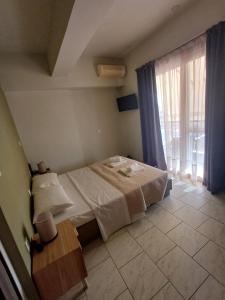 Un dormitorio con una cama y una mesa y una ventana. en Amalux, en Amaliás
