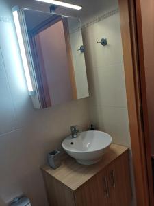 un baño con lavabo y espejo en Amalux, en Amaliás