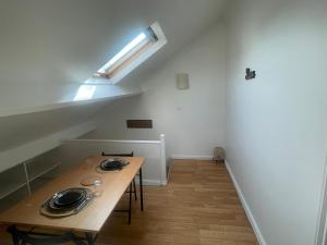 a dining room with a wooden table and a skylight at Duplex lumineux proche Paris in Villiers-le-Bel