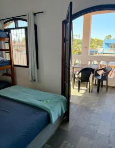 a bedroom with a bed and a balcony with a table at Pousada Ocean Próx Sesc Bertioga - Beira Mar in Bertioga