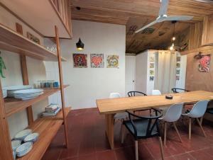 a dining room with a wooden table and chairs at Don Jiménez Guesthouse in Puerto Jiménez