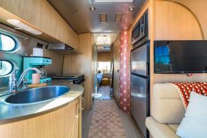 a kitchen in an rv with a sink and a tv at The Outpost Grand Canyon in Williams +85 photos