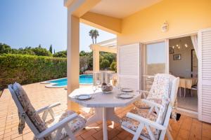 eine Terrasse mit Tisch und Stühlen und einem Pool in der Unterkunft 420 Villa Maren in Lagos