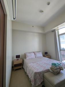 a white bedroom with a bed and a window at Saint Honore Megaworld in Iloilo City +23 photos
