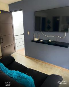 a living room with a couch and a tv on a wall at Alojamiento Familiar para 15 - Con 4 Piscinas - 3 Jacuzzi - Sauna By Molca Travel in La Tebaida