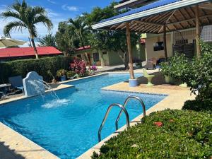 a swimming pool in a yard next to a house at Hotel La Fiore de Bahia in Uvita