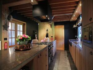 a large kitchen with wooden cabinets and a counter top at Houffalize Forest View Villa in Wibrin