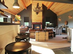 a living room with leather furniture and a fireplace at Houffalize Forest View Villa in Wibrin