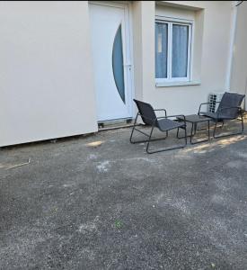 two chairs sitting in a parking lot next to a building at Sarah in Aix-les-Bains