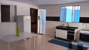 a kitchen with a refrigerator and a table in it at Espaço tá moiado in Guarulhos +5 photos