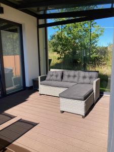 un patio con un sofá y un puf en Seaside Apartment, en Trzęsacz