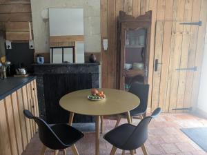 a table with chairs and a bowl of fruit on it at Studio Eco-Rénové in Saint-Christophe-sur-le-Nais
