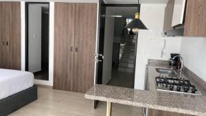 a kitchen with a sink and a bed in a room at Spacio30 in Bogotá