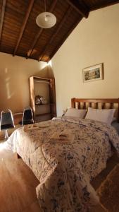a bedroom with a large bed with two chairs at Chalés Vitória in Cunha