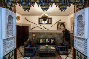 a living room with a couch and a chandelier at Spacious Apartment in Fès with Private Pool, 150 sqm in Fez