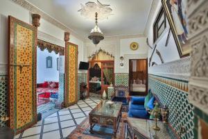 a living room with a blue couch and a table at Spacious Apartment in Fès with Private Pool, 150 sqm in Fez