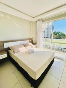 ein Schlafzimmer mit einem großen Bett und einem großen Fenster in der Unterkunft Home Resort - Beto Carrero - 3 quartos in Penha