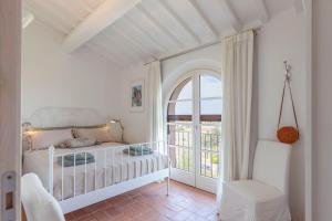 a white bedroom with a bed and a window at I Sette Ulivi in Laiatico +36 photos