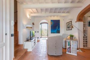 a living room with a couch and a television at I Sette Ulivi in Laiatico