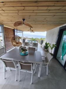 a dining room with a table and chairs at Cap'vanille in Saint-Philippe