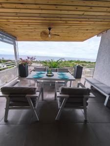 a table and chairs on a patio with a view at Cap'vanille in Saint-Philippe