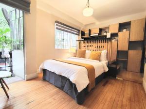 a bedroom with a large bed and a large window at Casa Pánuco in Mexico City