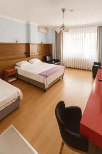 a bedroom with two beds and a desk and chairs at Ferah Otel in Gebze +21 photos