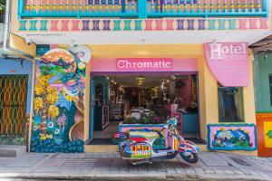 un scooter estacionado frente a una tienda en Hotel Chromatic, en Guatapé