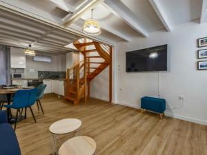 a living room with a staircase and a table and chairs at Cocon Tête d'or in Lyon