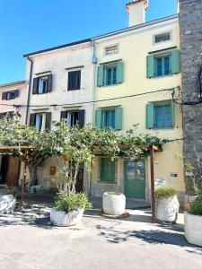 a building with green doors and trees in front of it at Casa Valentina in Piran +41 photos