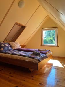 a bed in a room with a window at Domki Pod Lasem in Macharce