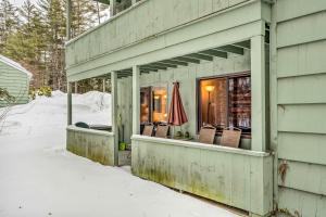 a house with chairs on the porch in the snow at 1 Mi to Attitash Mountain: Condo w/ Resort Perks in Bartlett