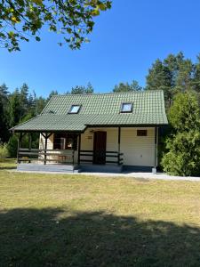a house with a porch and a garage at Domki Pod Lasem in Macharce