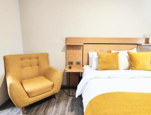 a hotel room with a bed and a chair at Casa Pánuco in Mexico City