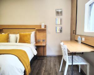 a bedroom with a bed and a table with a chair at Casa Pánuco in Mexico City