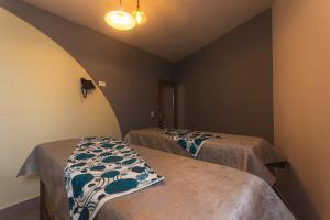 a room with two beds in a room at Hotel Chromatic in Guatapé