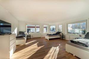 un ampio soggiorno con mobili e finestre bianchi di Monteur- & Gästewohnung mit Küche, WLAN & Parkplatz - SCH04 a Schramberg