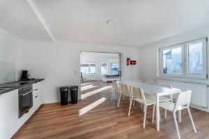 una cucina e una sala da pranzo con tavolo e sedie bianchi di Monteur- & Gästewohnung mit Küche, WLAN & Parkplatz - SCH04 a Schramberg