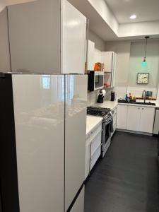een keuken met witte kasten en een koelkast bij Luxe in the Lou in Saint Louis