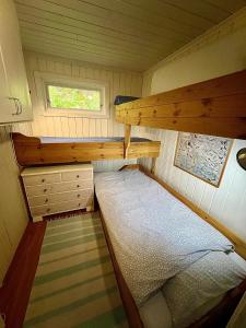 una piccola camera con letto a castello in una piccola casa di Cabin at Hestsjøen Badeplass a Trondheim