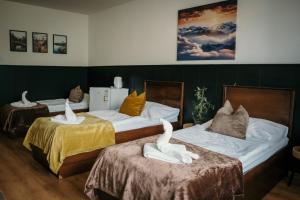 a room with two beds with swans on them at Podlesanka Vysoké Tatry in Smokovce