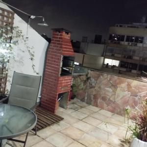 a brick pizza oven on a patio with a table at Cobertura posto 5 in Rio de Janeiro