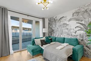 a living room with a blue couch and a window at Balcony Apartment I Direct connection to the Airport in 15 Min in Vienna