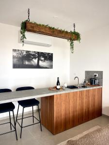 une cuisine avec un comptoir, un évier et des tabourets dans l'établissement Calma Hermon Guest Rooms, à Neve Ativ